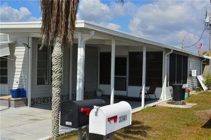 View of side of property with a sunroom and a yard