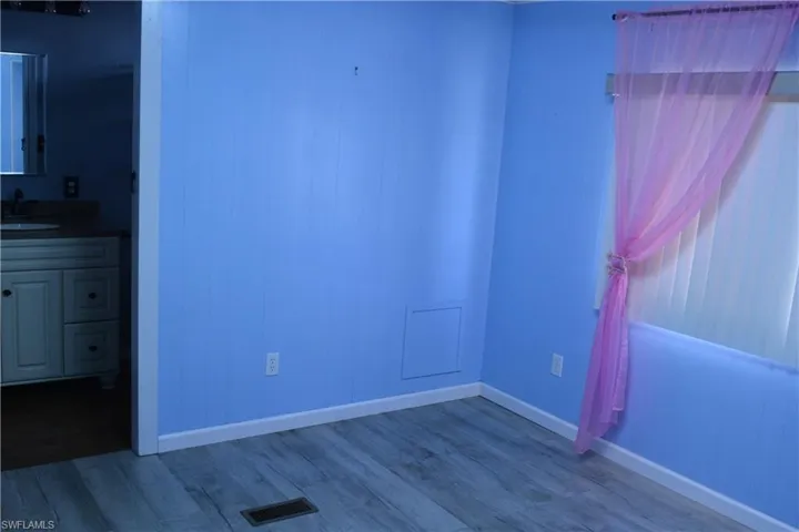 Unfurnished bedroom with dark wood finished floors and baseboards
