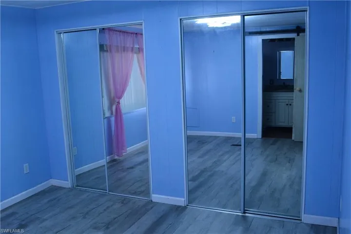 Unfurnished bedroom featuring multiple closets and wood finished floors