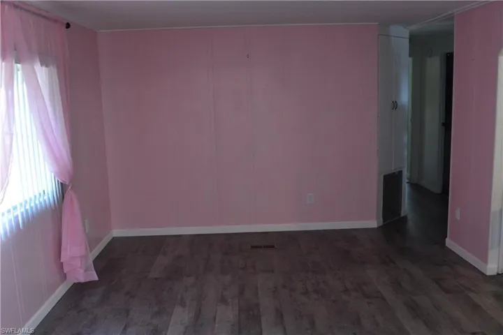 Spare room featuring dark wood-type flooring