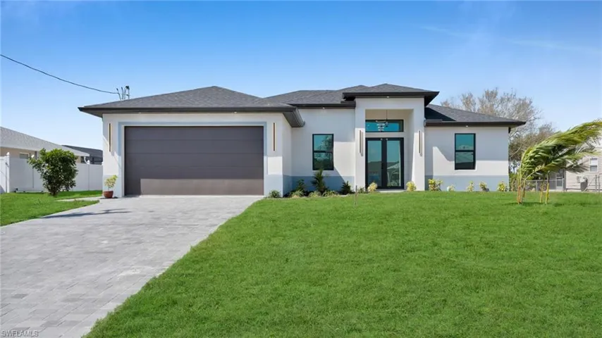 Prairie-style home featuring stucco siding, a garage, decorative driveway, and a shingled roof