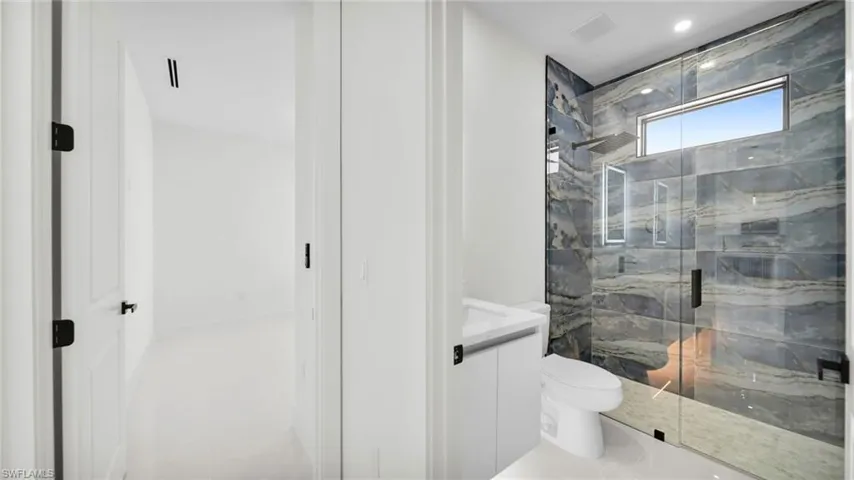 Full bath with vanity and a marble finish shower