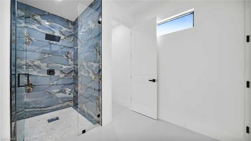 Full bath featuring a marble finish shower
