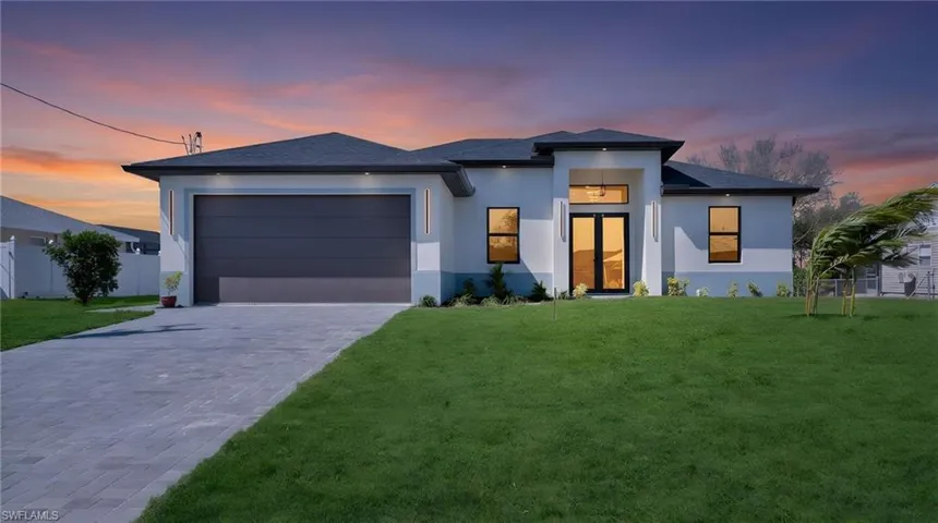Prairie-style house featuring stucco siding, a garage, decorative driveway, and a shingled roof