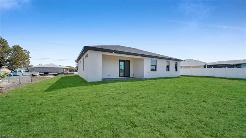 Back of house with a patio, stucco siding, and roof with shingles