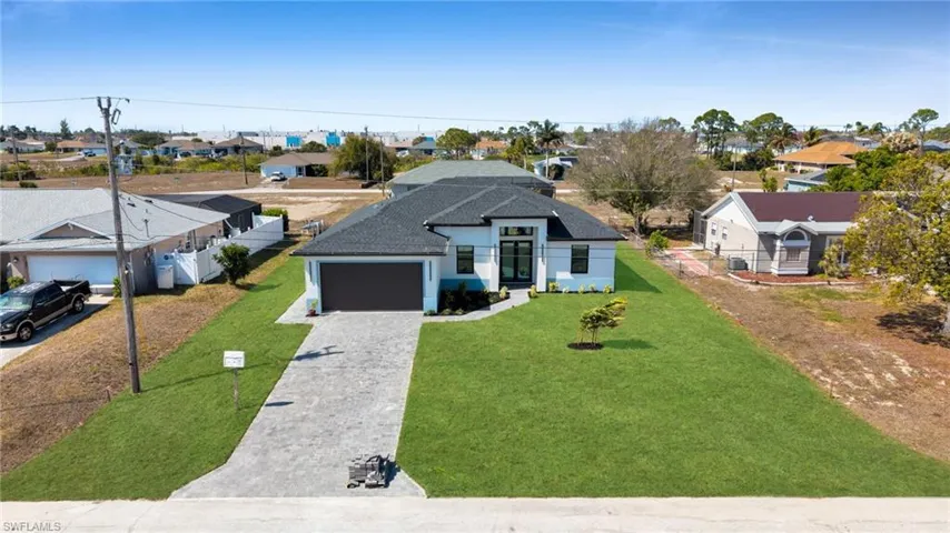 View of front of house with a residential view, decorative driveway, an attached garage, a shingled roof, and stucco siding