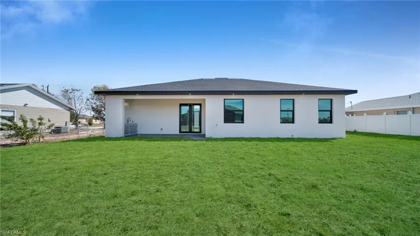 Rear view of house featuring stucco siding, a patio area, and roof with shingles