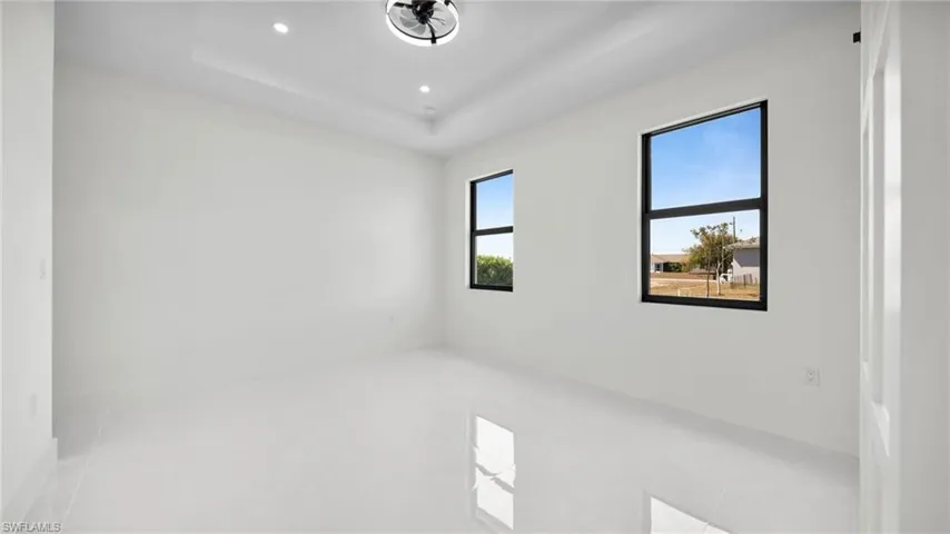 Empty room with recessed lighting and a raised ceiling