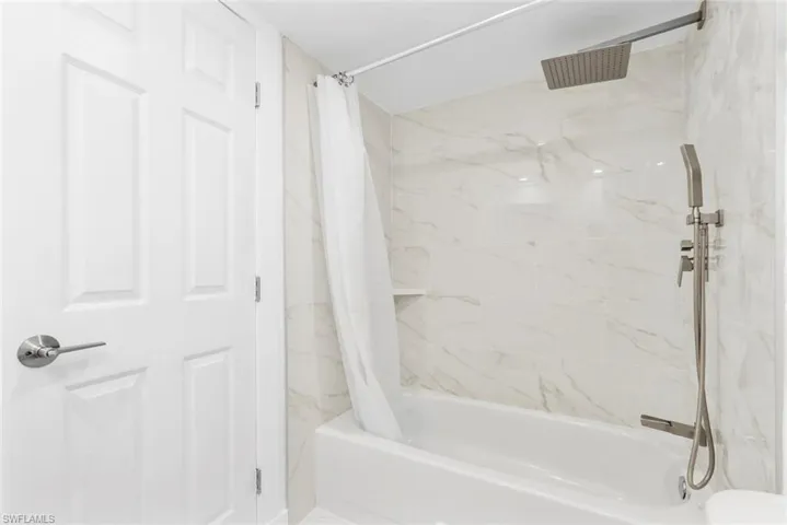 Full bathroom featuring a combined bath / shower with marble appearance