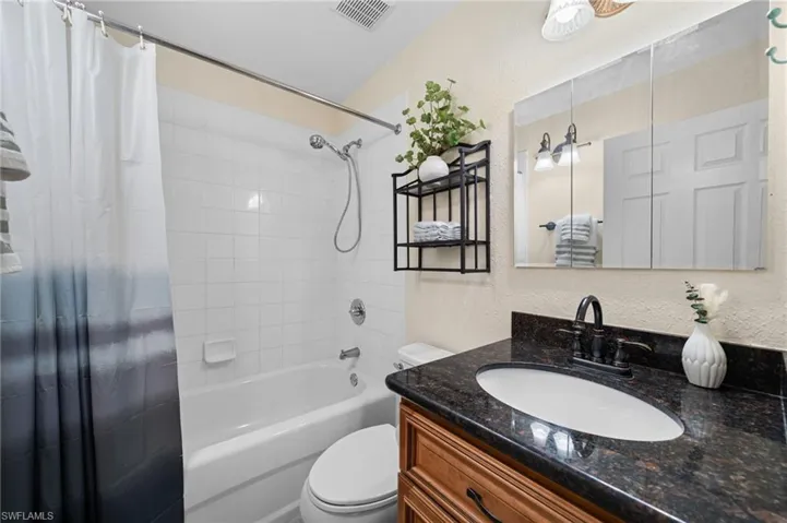 Full bathroom featuring shower / bath combo, vanity, and toilet