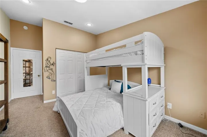 Bedroom with light carpet and a closet