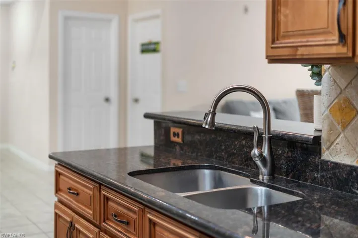 Kitchen with dark stone counters and sink