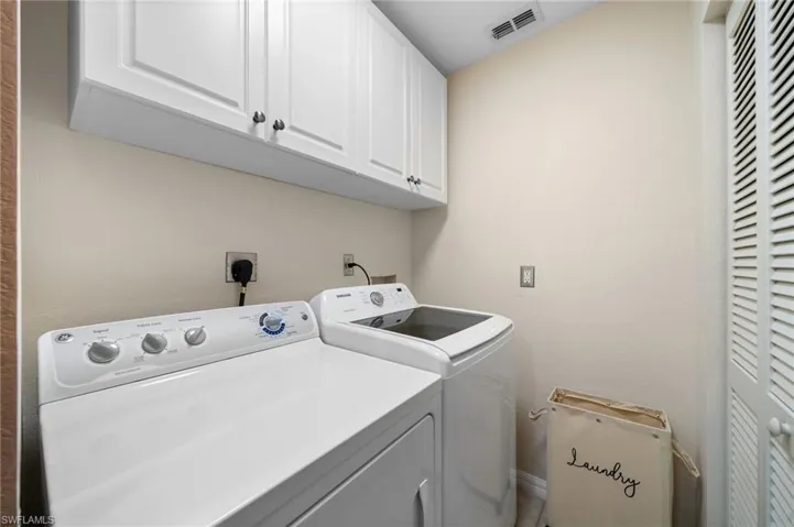 Laundry room with cabinets and washing machine and clothes dryer