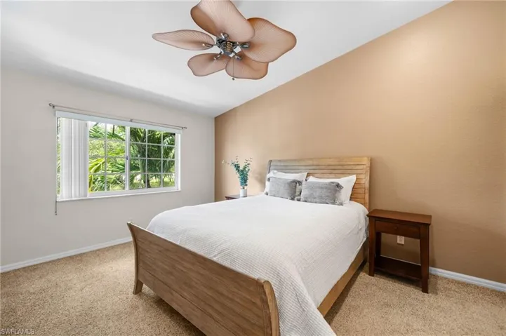 Carpeted bedroom featuring ceiling fan