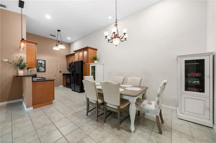Dining room featuring sink, a chandelier, and light tile patterned floors