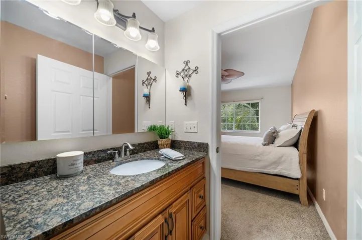 Bathroom with vanity and lofted ceiling