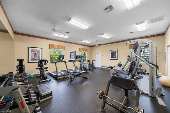 Exercise room with a textured ceiling and ceiling fan