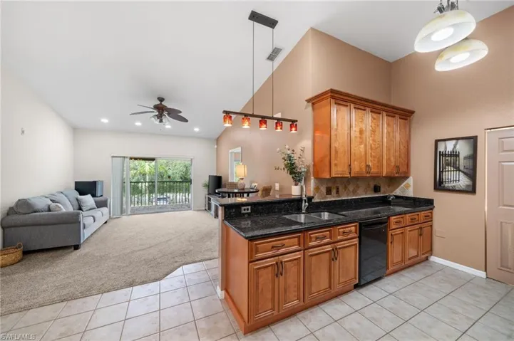 Kitchen featuring black dishwasher, light tile patterned flooring, sink, and ceiling fan
