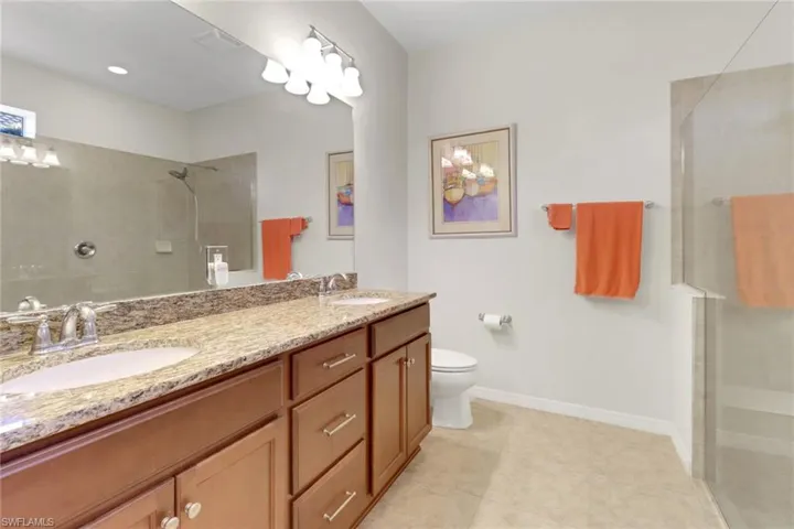 Primary Bathroom with extra large tiled shower, vanity, and toilet