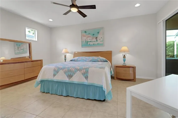 Bedroom with multiple windows, ceiling fan, and light tile patterned floors
