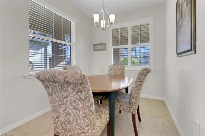 Tiled eat in kitchen area with a chandelier & plenty of natural light