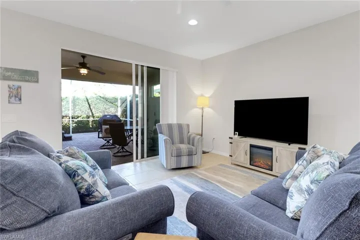 Living room with ceiling fan and light tile patterned floors