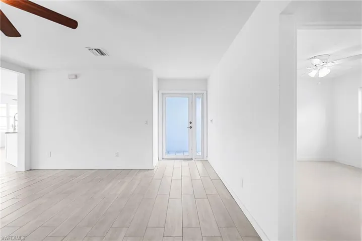 Unfurnished room featuring ceiling fan, wood tiled floors, and healthy amount of natural light