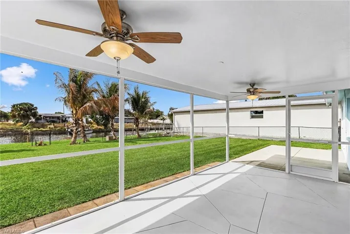 Unfurnished sunroom with a ceiling fan and a water view