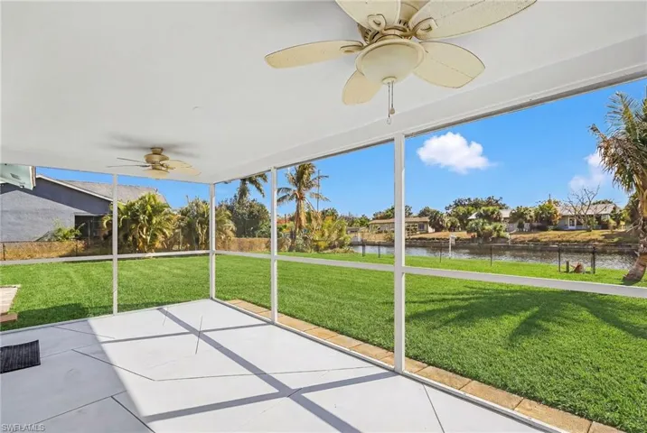 Unfurnished sunroom featuring a ceiling fan and a residential view