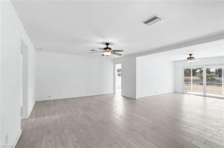 Empty room featuring a ceiling fan and light wood-type flooring