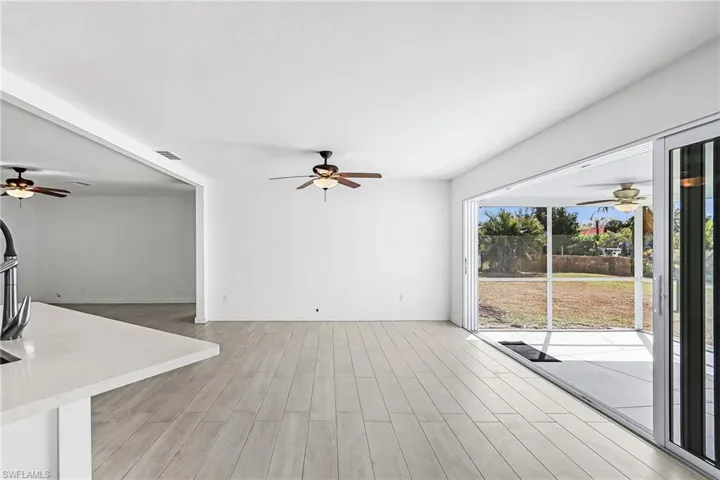 Unfurnished living room with ceiling fan and wood finish floors