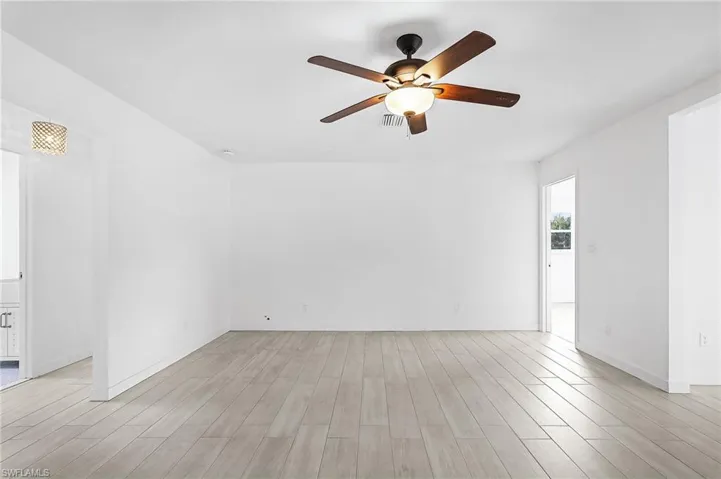 Empty room with light wood finished floors and ceiling fan