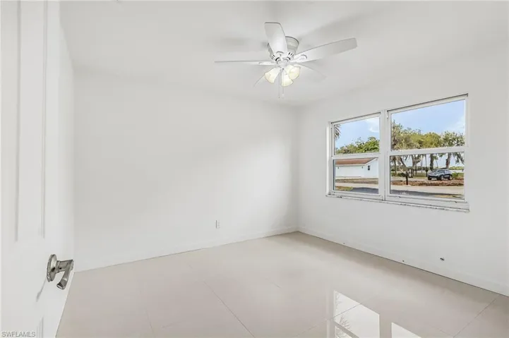 Spare room with ceiling fan and baseboards