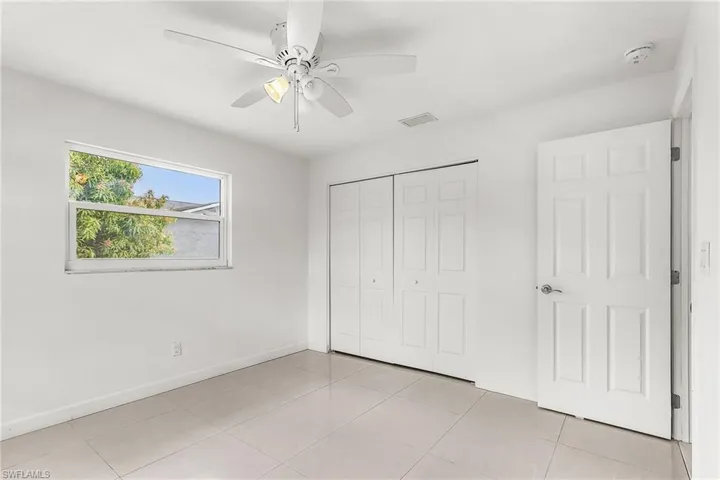 Unfurnished bedroom featuring a closet, ceiling fan, and light tile patterned flooring