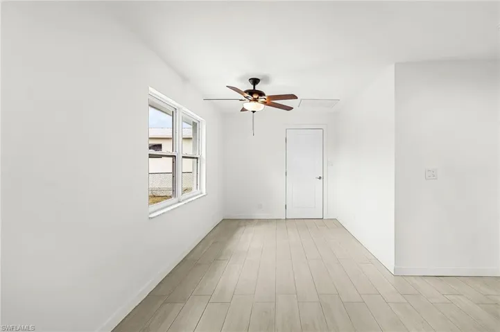 Empty room with ceiling fan and wood tiled floors