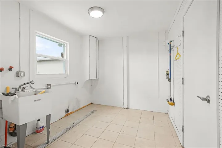 Laundry room with cabinet space and light tile patterned flooring