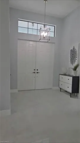Entrance foyer with plenty of natural light, a chandelier, and a towering ceiling
