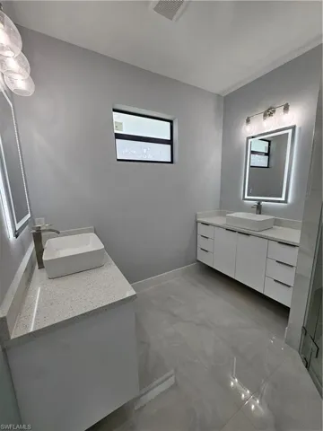 Bathroom with two vanities and baseboards