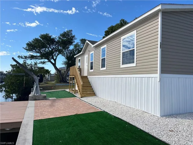 View of property exterior featuring a patio and a lawn
