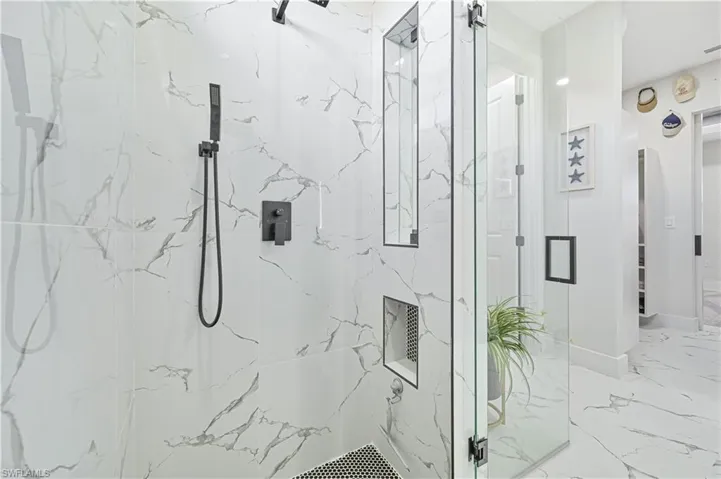 Full bathroom with marble finish floor and a marble finish shower
