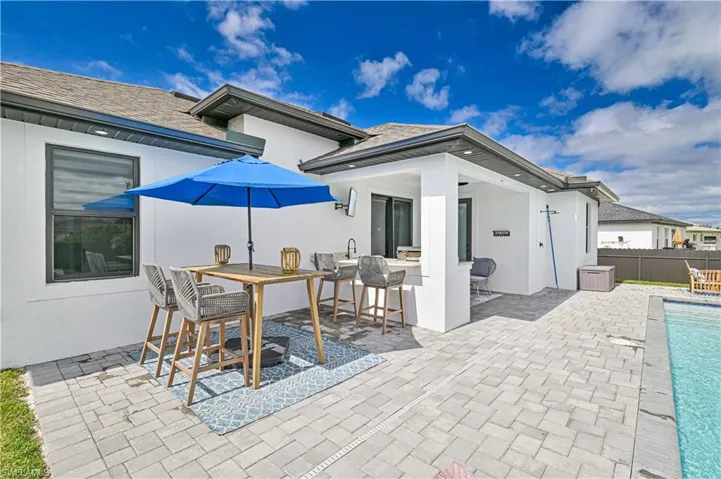 View of patio / terrace featuring fence, outdoor dry bar, a fenced in pool, and outdoor dining space