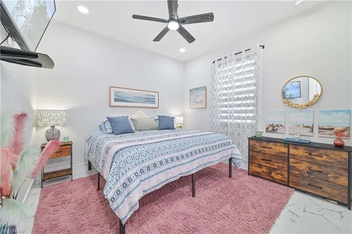 Bedroom featuring marble finish floor, a ceiling fan, and recessed lighting