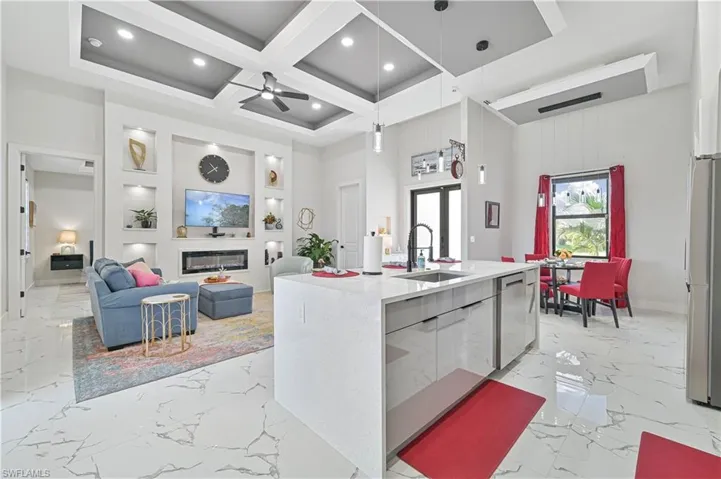 Kitchen with marble finish floor, a glass covered fireplace, a sink, coffered ceiling, and dishwasher