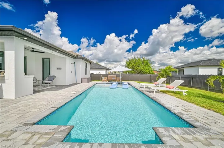View of pool featuring a patio, fence, and a ceiling fan