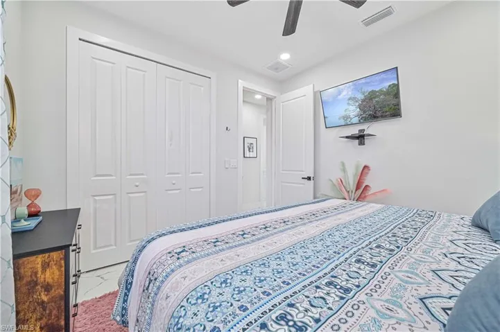 Bedroom featuring a ceiling fan, visible vents, and a closet