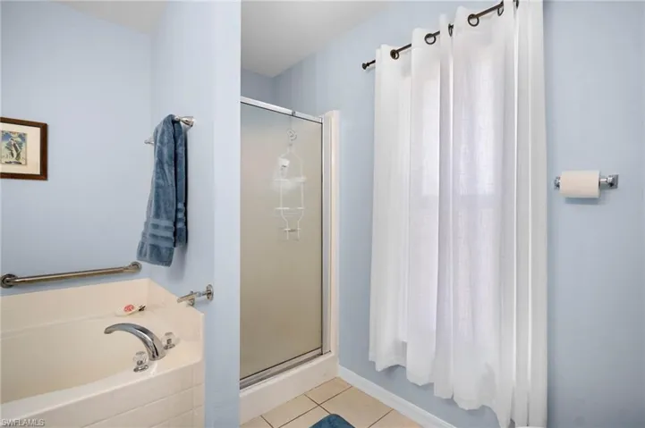 Bathroom with a stall shower, a bath, and light tile patterned floors