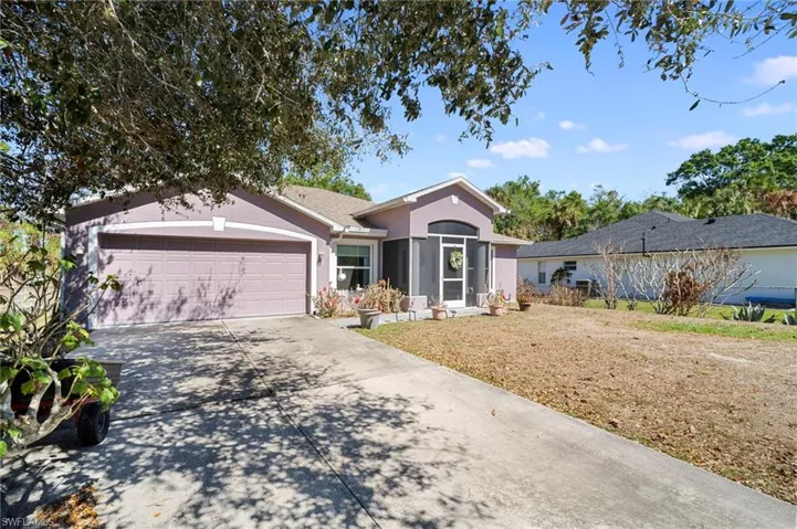 Single story home with stucco siding, a garage, concrete driveway, and a front yard