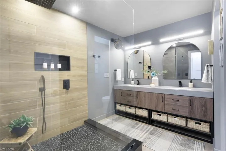 Bathroom featuring tiled shower, vanity, and toilet