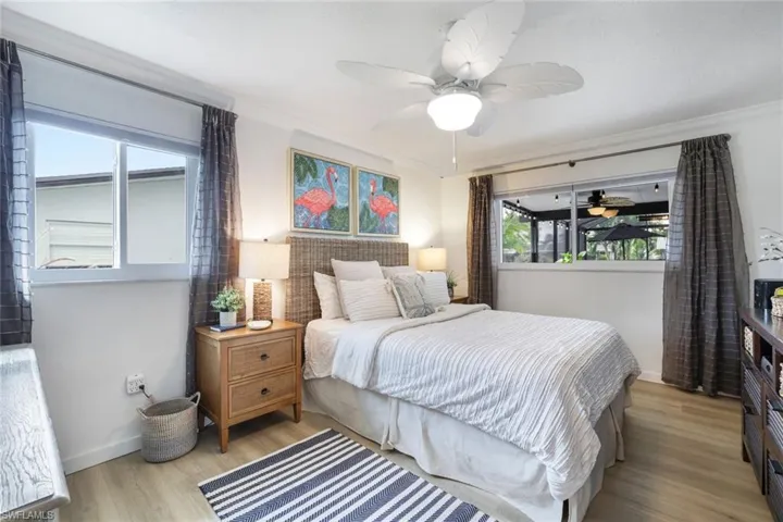 Bedroom featuring ceiling fan, ornamental molding, and light hardwood / wood-style flooring