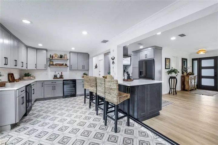 Kitchen featuring beverage cooler, gray cabinetry, and high quality fridge